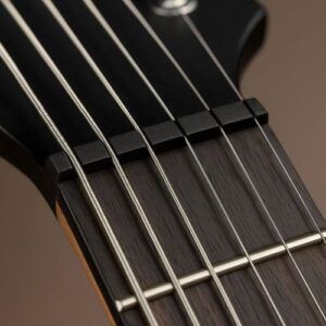 Black graphite nut close-up with subtle sheen, visible string slots, modern high-performance look.