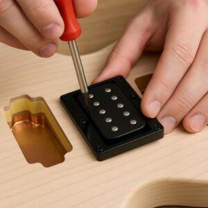 Builder tightening pickup screws gently with screwdriver