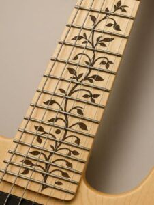 Maple fretboard featuring a detailed Tree of Life vine inlay pattern flowing along the frets.