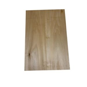 Light-colored hardwood guitar body blank with natural grain and small knots, photographed on a white background.