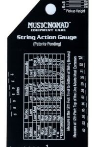 MusicNomad MN602 string action gauge showing etched measurement charts for electric, acoustic, and bass guitar setup, with black stainless steel finish and white precision markings.