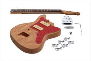 Unfinished offset-style DIY guitar kit with natural wood body, red tortoiseshell pickguard, cream P-90 pickups, separate maple neck, chrome bridge, tremolo arm, and tuning machines laid out on a white background.