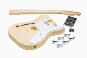 Unfinished Tele-style semi-hollow DIY guitar kit with maple neck, white pickguard, hardware, and electronics laid out on a white background.
