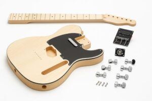 Unassembled Tele-style DIY guitar kit on a white background, featuring a maple body with black pickguard, separate maple neck, chrome hardware, pickups, and electronics neatly arranged.